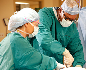 Healthcare providers performing surgery in operating room.